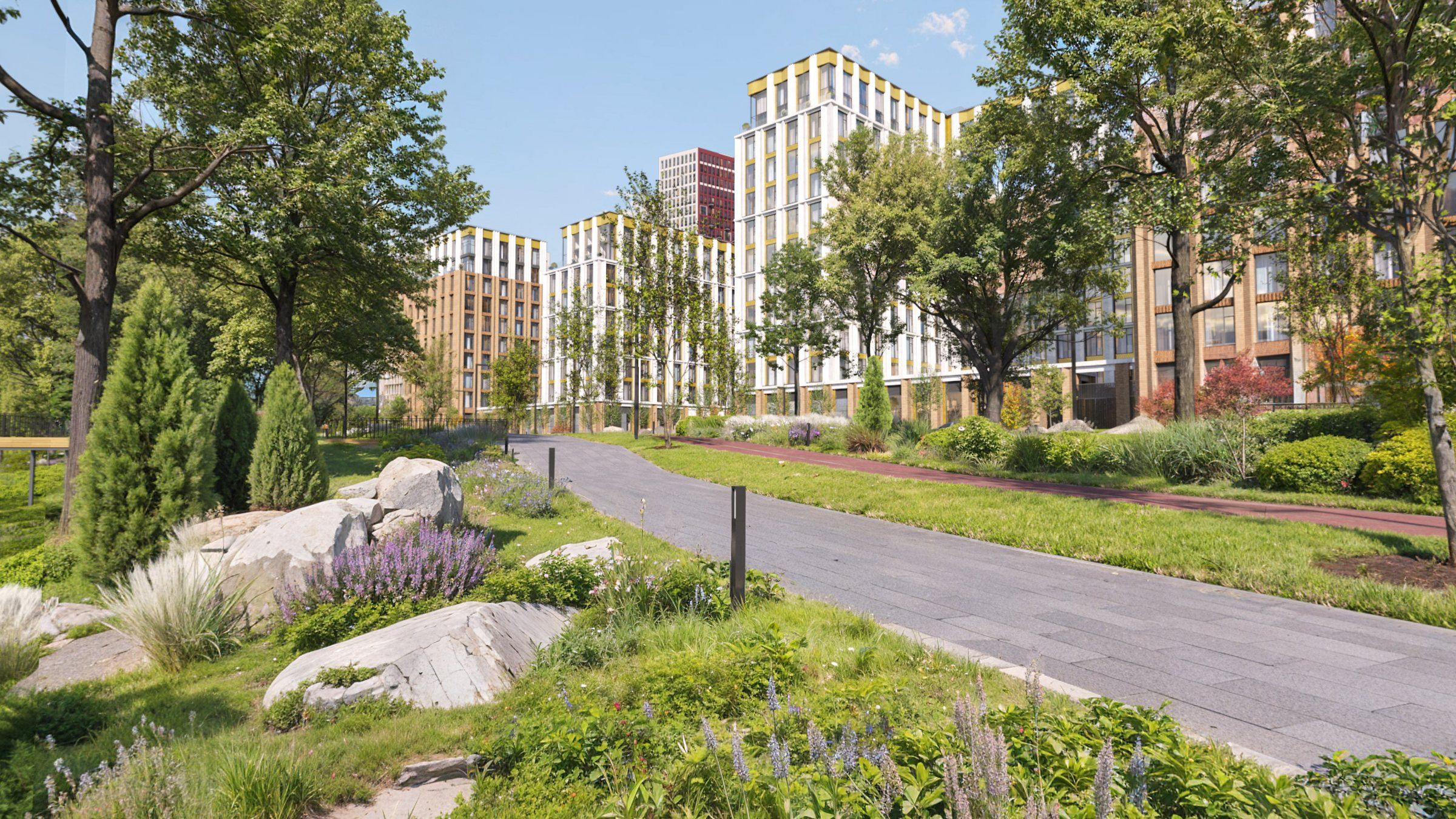 The riverside promenade with the development’s buildings rising behind the trees